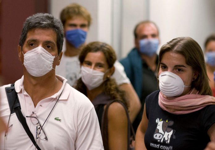 Argentine tourists wear surgical masks inside the airport in Mexico City