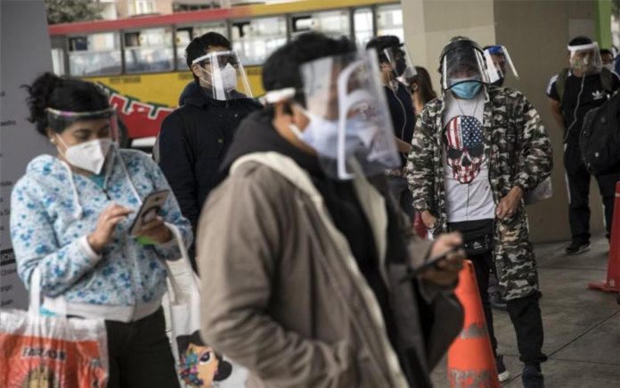 Personas con mascarillas por el coronavirus en Lima, Perú. / AP